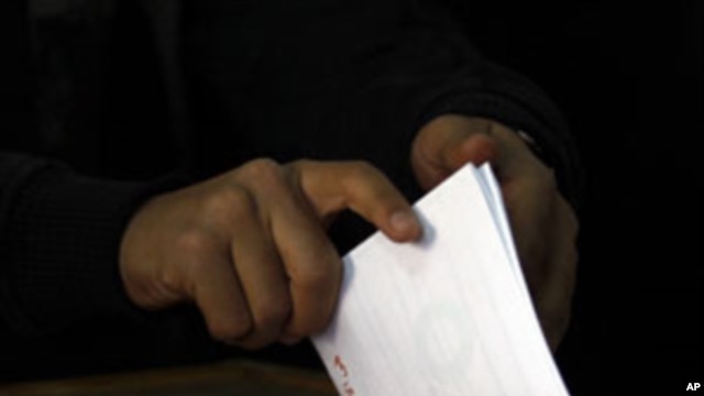 An Egyptian voter casts her vote in a polling station in Cairo, Egypt, March 19, 2011