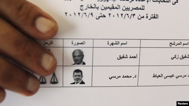 An Egyptian expatriate displays his ballot before casting his vote.