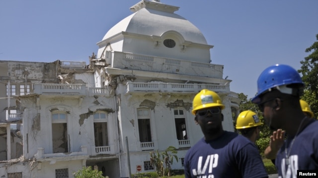 Workers from U.S. actor and Haiti's ambassador-at-large Sean Penn's charity J/P HRO (J/P Haitian Relief Organization) stand in front of the collapsed cupola of the condemned National Palace in Port-au-Prince, September 07, 2012. 