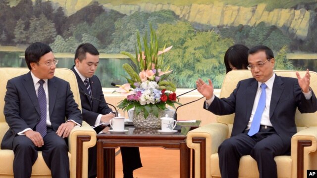 Bộ trưởng Ngoại giao Việt Nam (trái) lắng nghe ông Lý Khắc Cường trong cuộc hội kiến tại Bắc Kinh hôm 18/6.