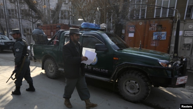Afghan policemen stand guard at site where US advisor was killed by Afghan policewoman in Kabul, December 24, 2012