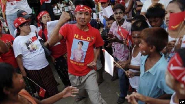 A man wearing a T-shirt bearing the image of Aung San Suu Kyi dances at campaign rally for the pro-democracy icon and her National League for Democracy, Rangoon, Burma, March 30, 2012. 
