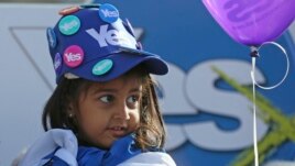 A young girl wears a 'Yes' hat, covered in 'Yes' badges, as Scotland's First Minister Alex Salmond campaigns in Edinburgh, Scotland.