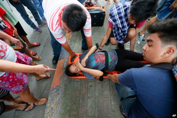 A protester who was run over by a Philippine National Police van waits for treatment outside the U.S. Embassy in Manila, Philippines, Oct. 19, 2016.