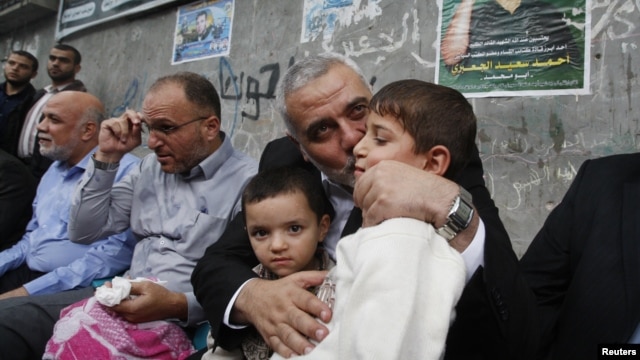 Pemimpin senior Hamas Ismael Haniyeh mencium anak kepala militer Hamas yang tewas dalam serangan udara Israel. (Foto: AP)