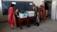 An army soldier talks to election officials whom female voters go to for their ballot papers, inside a booth at a polling station during a re-polling for the general elections in Karachi, May 19, 2013. 