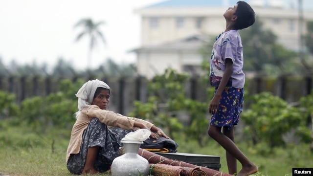 Rohingya Muslims people rest by the road with their belongings as they move from their village after recent violence in Sittwe, June 16, 2012. 