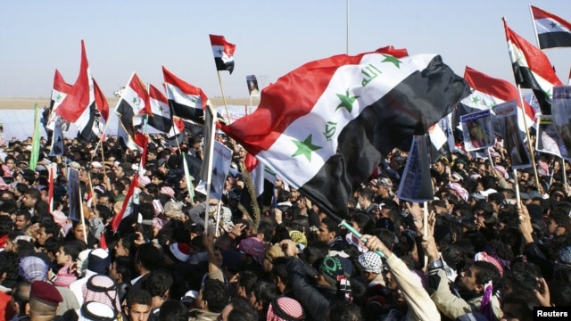 Iraqi Sunni Muslims wave the old flag of Iraq during an anti-government demonstration in Ramadi, 100 km (62 miles) west of Baghdad, December 26, 2012.