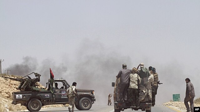 Rebel fighters enter the village of Al-Qawalish after a battle to seize control of the town from forces loyal to Libya's leader Moammar Gadhafi, July 6, 2011