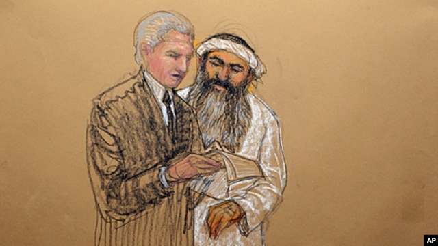 In this photo of a sketch by courtroom artist Janet Hamlin and reviewed by the U.S. Department of Defense, Khalid Sheikh Mohammed consults with his civilian attorney David Nevin during a break of his military hearing at the Guantanamo Bay U.S. Naval Base 