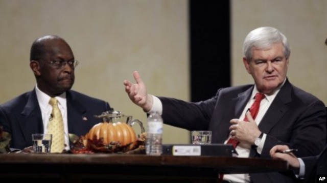 Republican presidential candidate former House Speaker Newt Gingrich speaks during the Thanksgiving Family Forum sponsored by The Family Leader as former CEO of Godfather's Pizza Herman Cain looks on,  in Des Moines, Iowa, November 19, 2011.