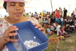 Bulungula Incubator health manager Nomzingisi Hopisi prepares to draw a name of the winner of the cellphone… She says a colleague’s death inspired innovative action against the spread of HIV in her home area . (D. Taylor/VOA)