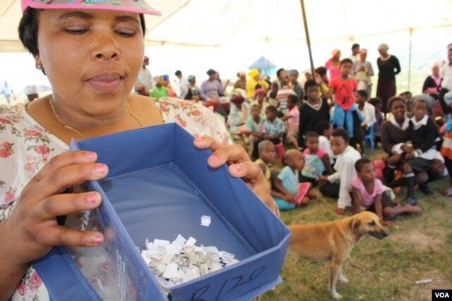 Bulungula Incubator health manager Nomzingisi Hopisi prepares to draw a name of the winner of the cellphone… She says a colleague’s death inspired innovative action against the spread of HIV in her home area . (D. Taylor/VOA)