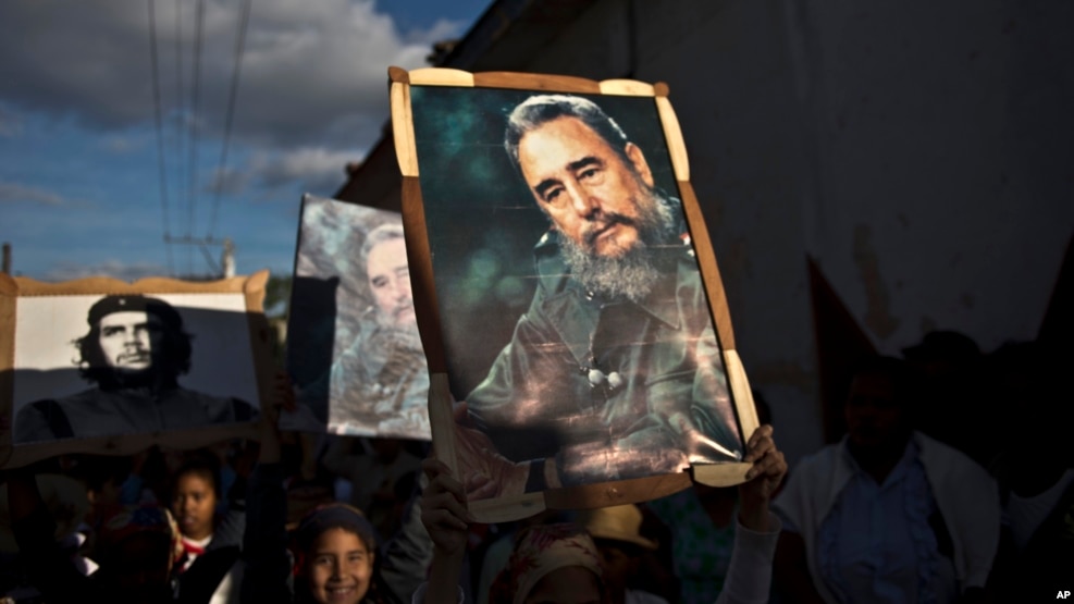 Những đứa trẻ mang theo những bức ảnh của Fidel Castro và Che Guevara trong một đoàn diễu hành tại Regla, Cuba, 08 tháng 1, 2015. 
