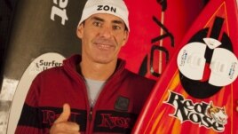 Garrett McNamara of Hawaii is pictured with his winning surf board which he rode in his November 10, 2011, quest, in this photograph released on May 11, 2012.