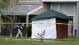 An FBI investigator walks to the apartment where a man was shot by an FBI agent, Wednesday, May 22, 2013, in Orlando, Fla.