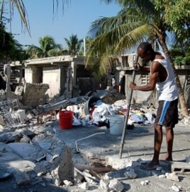 A man in Carrefour, Haiti, near the quake's epicenter, attempts to dig out whatever possessions he can salvage from his destroyed home, 25 Jan 2010