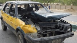 A car damaged by a bomb blast is seen in front of police headquarters in Nigeria's northeastern city of Maiduguri June 8, 2012.