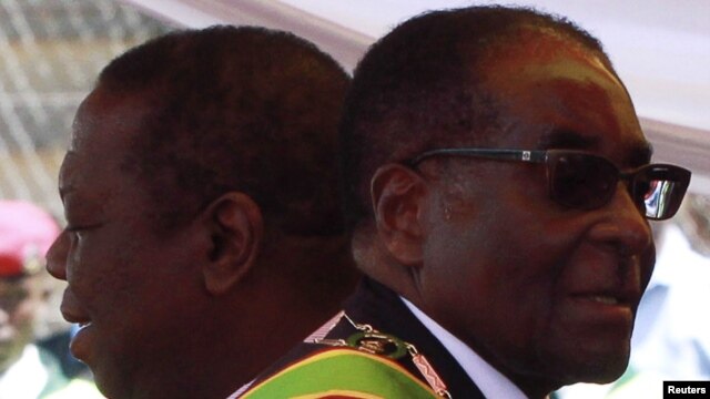 Zimbabwean President Robert Mugabe (R) and Prime Minister Morgan Tsvangirai arrive at a rally marking Zimbabwe's 31st independence anniversary celebrations in Harare, Zimbabwe, April 18, 2011. 