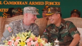 Lt. Gen. Hun Manet, right,  son of Cambodian Prime Minister Hun Sen and deputy commander of the Royal Cambodian Army and Commander of the National Counter Terror Special Force, talks with an U.S. Army Pacific Representative Brg. Gen. John Goodale, left, as they preside over a U.S.-backed peacekeeping exercise dubbed "Angkor Sentinel 2014" at the Cambodian tank command headquarters in Kampong Speu province, 60 kilometers (37 miles) west of Phnom Penh, Cambodia, Monday, April 21, 2014. (AP Photo/Heng Sinith)