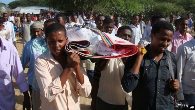 FILE - Somalis and local journalists carry the body of Moqtar Mohamed Hirab for burial in Mogadishu, Somalia.