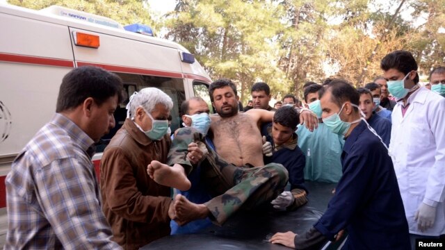 Residents and medics transport a Syrian Army soldier, wounded in what they said was a chemical weapon attack near Aleppo, to a hospital, March 19, 2013.