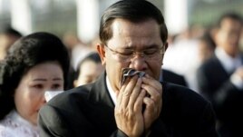 Cambodian Prime Minister Hun Sen and his wife Bun Rany cry during a memorial service near a bridge where festival goers were killed Monday in a stampede in Phnom Penh, Cambodia, Thursday, Nov. 25, 2010. (AP Photo/Sakchai Lalit)