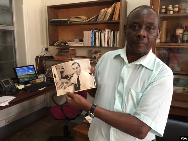 Louis Mukwaya, a mosquito researcher at the Uganda Virus Research Institute near Entebbe, displays a photograph of a Scottish medical entomologist. Alexander Haddow led the research team responsible for isolating the Zika virus in 1947. (J. Craig/VOA)
