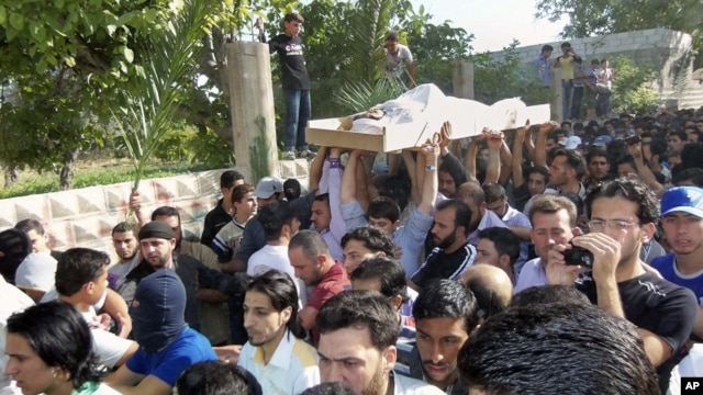 Anti-Syrian regime mourners chant slogans as they carry the body of soldier Khaled Shurbajy, who was shot by Syrian security forces in Dir el Zour last week after disobeying orders to fire on anti-Assad protesters, May 26, 2012