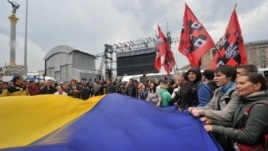 Protesters wave a giant Ukrainian flag during a protest rally in Kiev on June 5, 2012.
