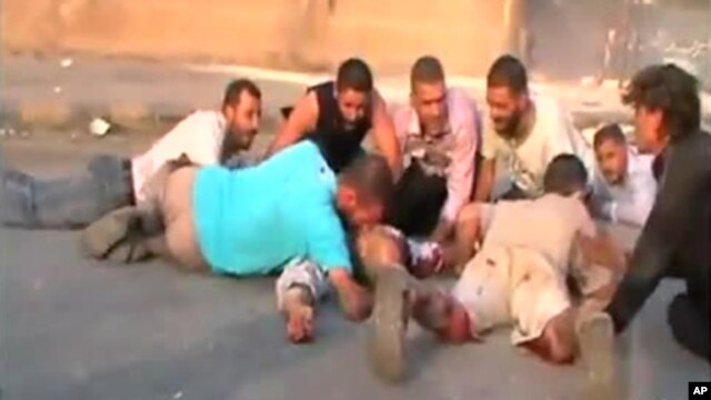 An image grab from a video uploaded on YouTube on July 31, 2011 shows Syrians seeking cover from shooting allegedly by security forces in the city of Hama.