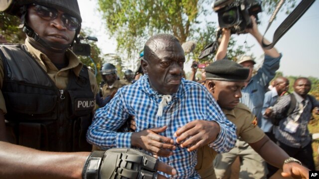 FILE - Uganda's main opposition leader Kizza Besigye, center, is arrested by police and thrown into the back of a blacked-out police van which whisked him away and was later seen at a rural police station, outside his home in Kasangati, Uganda, Feb. 22, 2016.
