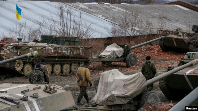 Binh sĩ Ukraine bên cạnh các xe quân sự và vũ khí được rút ra khỏi khu vực Horlivka, gần Druzhkivka, miền đông Ukraine, ngày 28/2/2015.