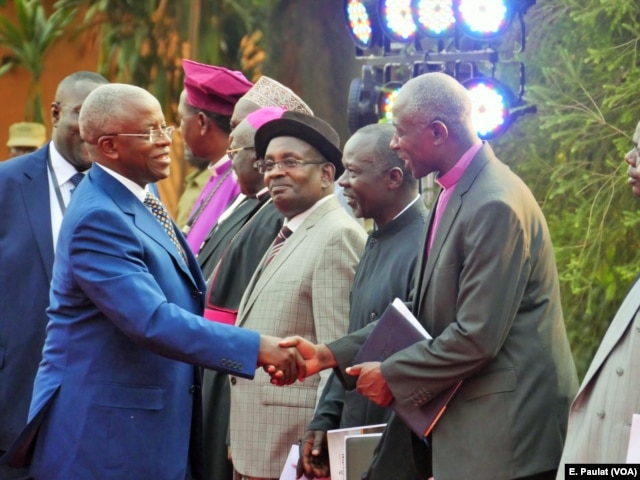 Presidential aspirant and former Prime Minister Amama Mbabazi arrives at the debate in Kampala, Feb. 13, 2016, greeted by the Inter-Religious Council of Uganda.