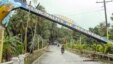 Motorists drive past a fallen marker that was toppled by Tropical Storm Jangmi at Alcantara township, Cebu province, central Philippines, Dec. 30, 2014.