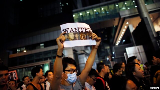 Sinh viên biểu tình ủng hộ dân chủ cầm biểu ngữ với hình ảnh một người biểu tình bị cảnh sát đánh đập tại quận Wan Chai ở Hồng Kông.