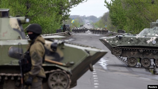 Binh sĩ Ukraine canh gác phía trước xe bọc thép tại một chốt kiểm soát gần làng Malinivka, miền đông Ukraine, ngày 29/4/2014.