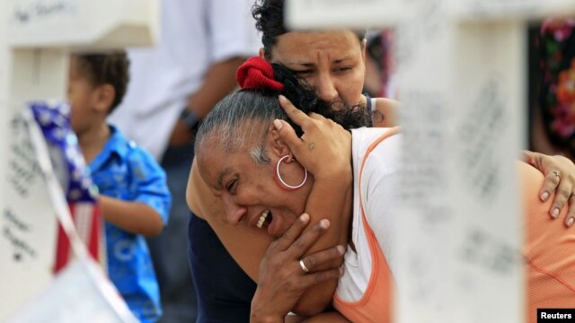 Denise Paba, who lost her 6-year-old niece Veronica Moser, is comforted as she cries at a memorial for victims behind the theatre where a gunman opened fire last Friday on moviegoers in Aurora, Colorado July 22, 2012. 