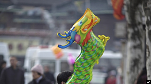 A man holds a dragon balloon outside Longhua Buddhist Temple on the first day of the Chinese Lunar New Year in Shanghai, January 23, 2012.