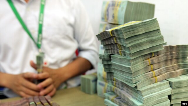 Ảnh minh họa: Nhân viên chuẩn bị tiền cho khách hàng tại một ngân hàng ở Hà Nội.