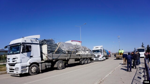 Trucks carry tents and construction material to be used for make-shift refugee housing, in Oncupinar, Turkey, Feb. 8, 2016. The supplies are destined for refugees on Syrian territory whom Ankara refuses entry into Turkey. (Photo - J. Dettmer/VOA)