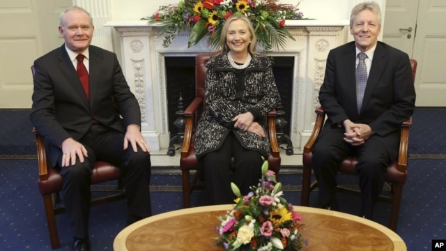 In this image released by Northern Ireland Government Assembly, showing US Secretary of State Hillary Rodham Clinton, centre, sitting with First Minister Peter Robinson, right, and deputy First Minister Martin McGuinness, as they pose together in Belfast 