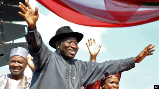 Nigerian President Goodluck Jonathan (C), accompanied by his wife Patience (R), Vice President Namadi Sambo, waves to the crowd before their campaign declaration in Abuja on September 18, 2010.