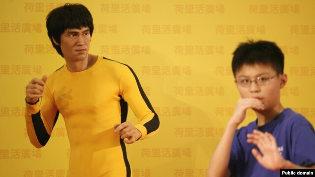 ေဟာင္ေကာင္က Bruce Lee ႐ုပ္တုေရွ႕မွာ ကေလးငယ္တဦး ဟန္ေရးျပေနပံု။ 
(ဇူလိုင္လ ၂၀ ရက္၊ ၂၀၁၃)။