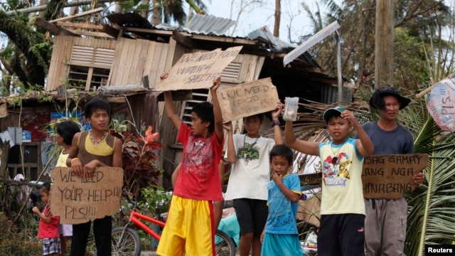 Trẻ em Philippines cầm bảng kêu gọi sự giúp đỡ dọc theo con đường cao tốc tại thị trấn Tabogon trong tỉnh Cebu, miền Trung Philippines, ngày 11/11/2013.