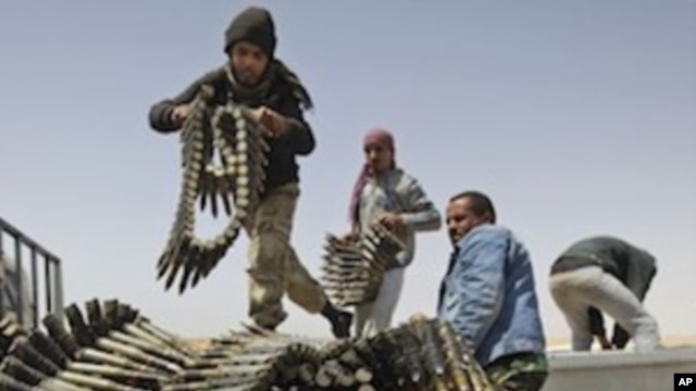 Libyan rebel fighters load a truck with ammunition on the outskirts of Ajdabiya, Libya, Saturday, April 16, 2011.