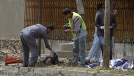 Afghan policemen investigate at the site of suicide attack in Kabul, September 8, 2012. 