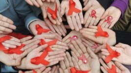 University students hold red ribbons at a photo opportunity during an HIV/AIDS awareness rally on World AIDS day in Chengdu, Sichuan province December 1, 2009. REUTERS/Stringer (CHINA HEALTH SOCIETY) CHINA OUT. NO COMMERCIAL OR EDITORIAL SALES IN CHINA