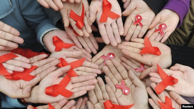 University students hold red ribbons at a photo opportunity during an HIV/AIDS awareness rally on World AIDS day in Chengdu, Sichuan province December 1, 2009. REUTERS/Stringer (CHINA HEALTH SOCIETY) CHINA OUT. NO COMMERCIAL OR EDITORIAL SALES IN CHINA
