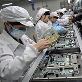 Chinese workers assemble electronic components at the Taiwanese technology giant Foxconn's factory in Shenzhen, Guangzhou province (File)
